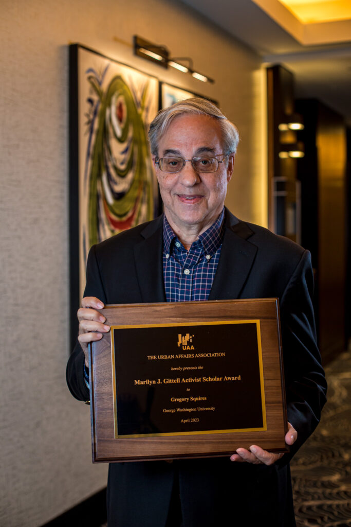 Greg Squires holding award plaque