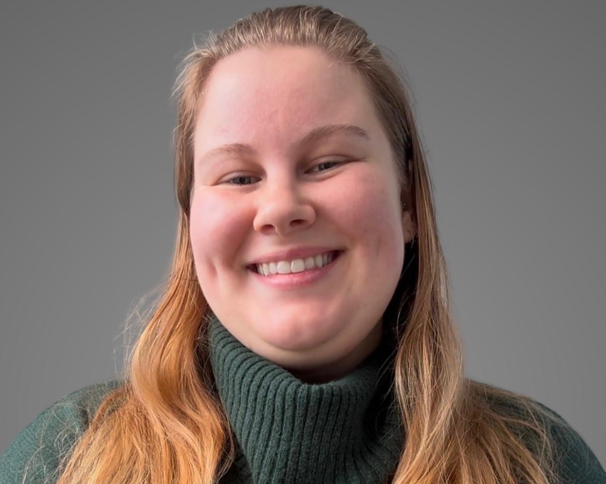 Marissa Mowers, a white woman, poses in a green sweater 
