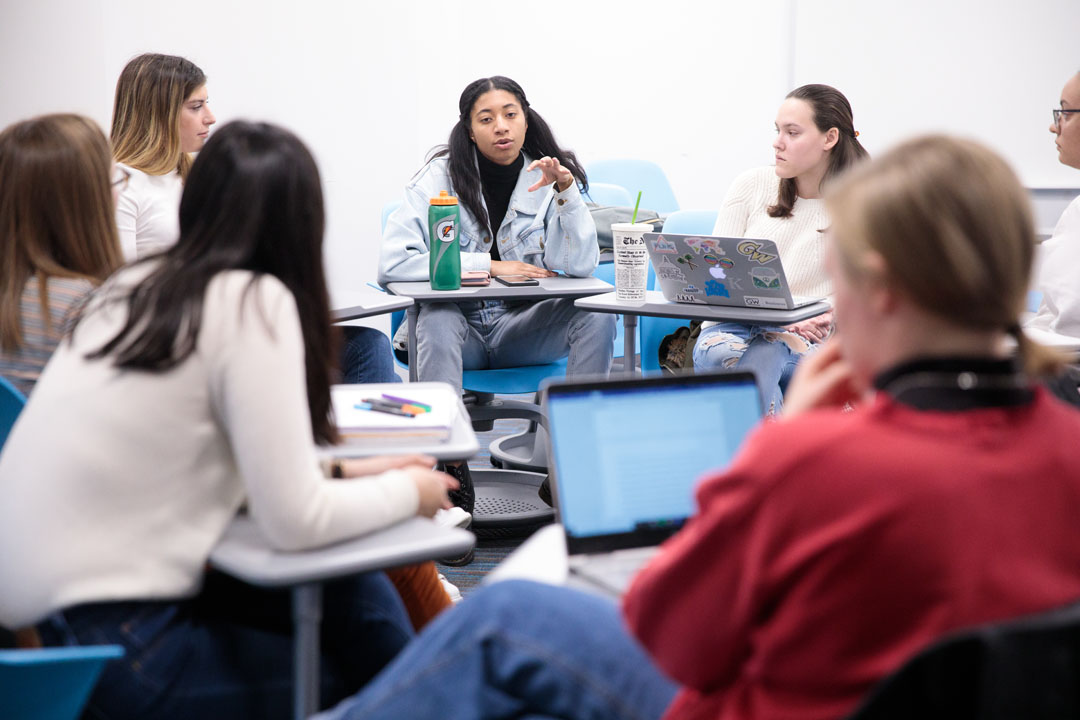 A ring of students talking in a classroom