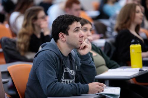 A close-up of a student sitting at a desk in class