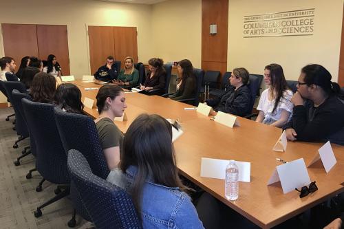 Florida Bar Foundation President Juliette E. Lippman, BA ’90, speaks at a conference table with sociology students at a GW panel event on the crisis for funding in legal aid.