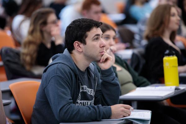 A close-up of a student sitting at a desk in class